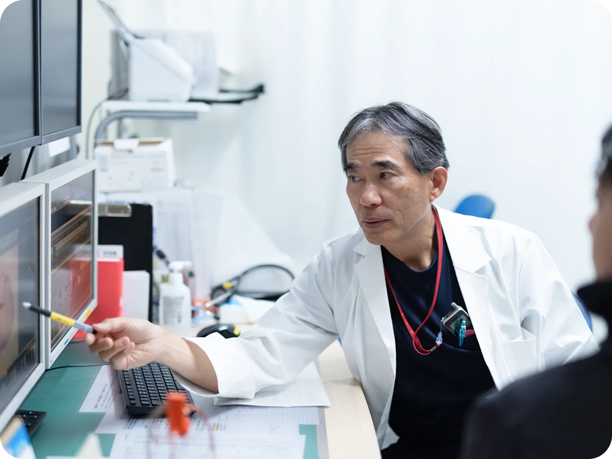 医師がモニターで脳の画像を確認しながら患者に説明している様子